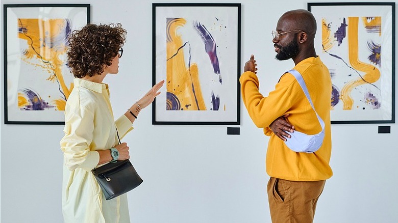 Two people discussing art piece