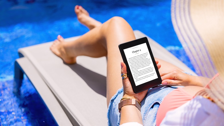 A reclining poolside with an e-book on a tablet