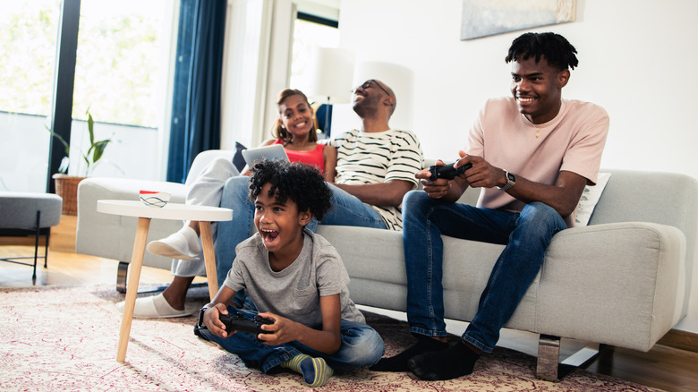 A family on a sofa gaming on different devices