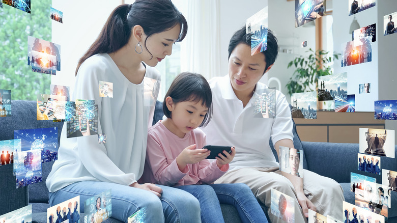 A family sharing a mobile screen on the couch