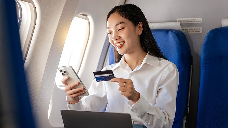 Plane passenger smiling, using devices