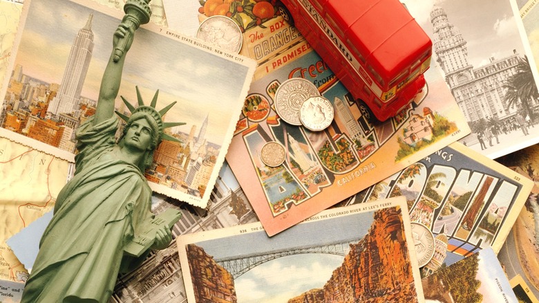 Statue of Liberty figurine with a spread of tourist postcards, coins, and other travel keepsakes