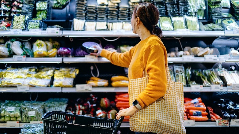 Person choosing packaged grocery produce