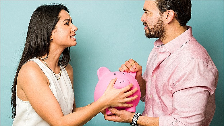 couple arguing over piggy bank