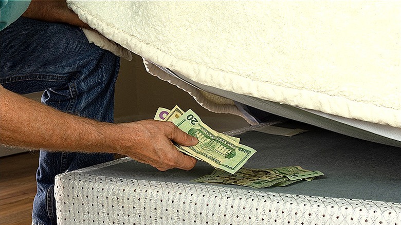 person hiding money under mattress