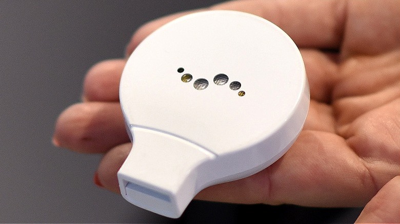 A hand holding a Breathometer device