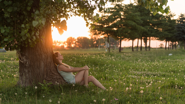 Woman relaxing under tree