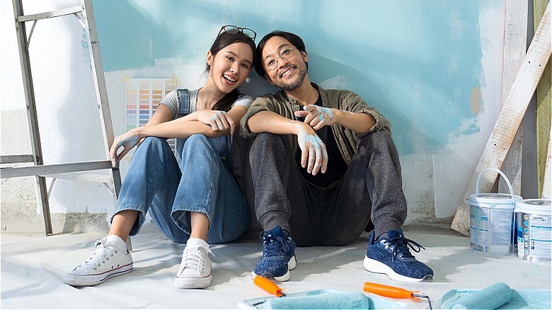 Couple painting home, taking break