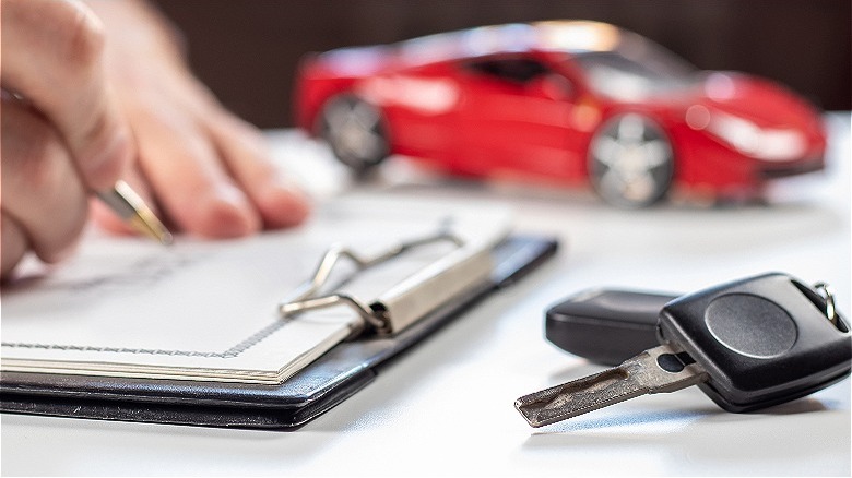 Car keys, person signing papers