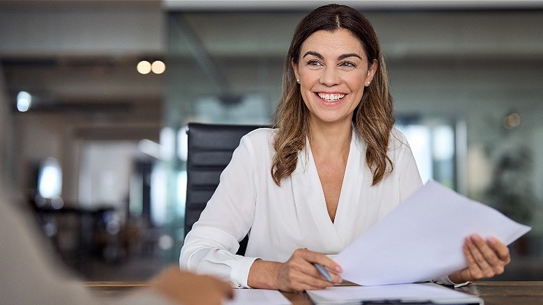 Person smiling with papers