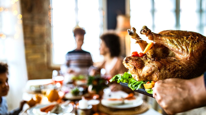 Person carrying cooked turkey to table