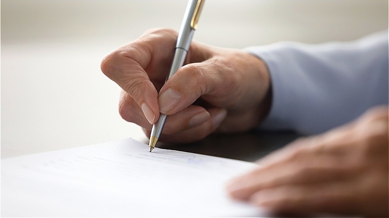 Older person signs paperwork