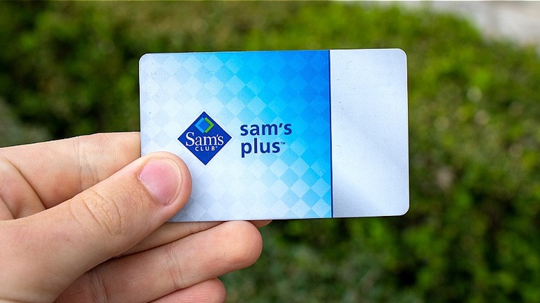 A hand holds a Sam's Plus membership card outside