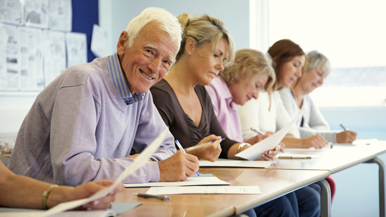 A grouping of older students sitting at a long table.