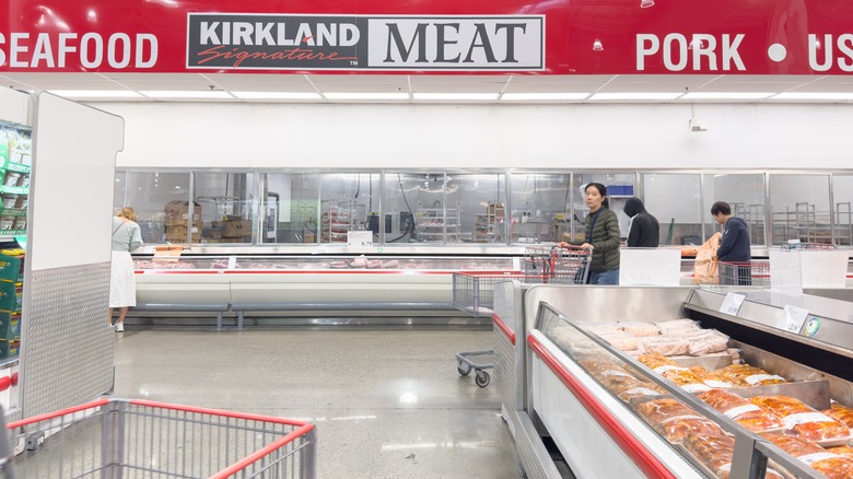 A wide view of the Costco meat counter and the surrounding fluorescent-lit aisle.