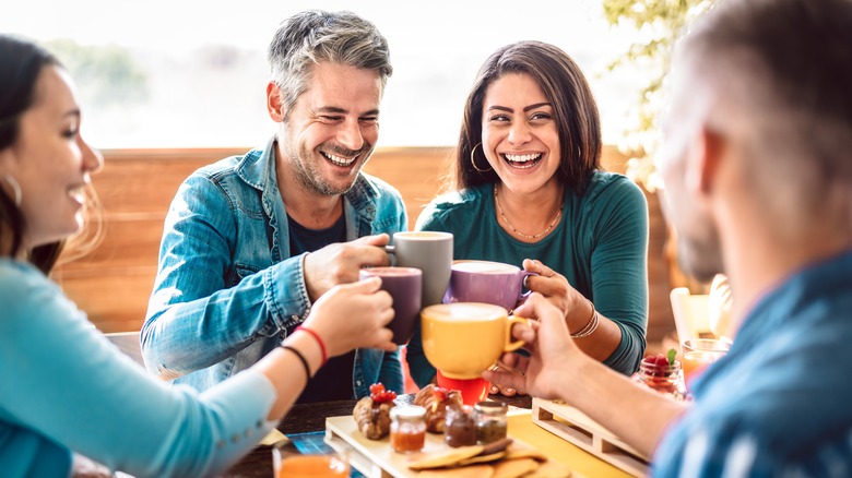 Smiling friends drinking lattes