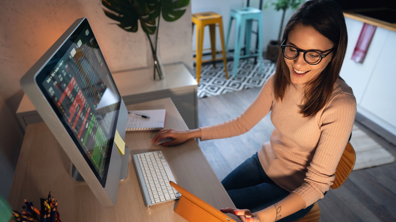 A smiling woman trading stocks