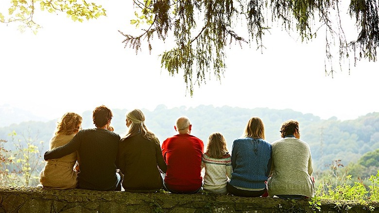 Multi-generation family sitting on wall