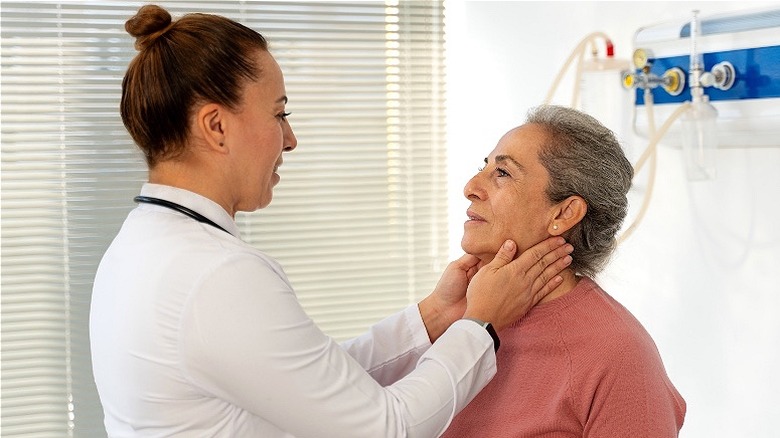 Doctor feels patient's throat