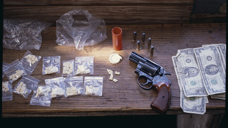 Money, a revolver, and bags of crack on a table.