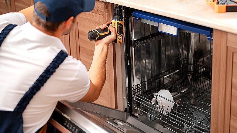 person repairing a dishwasher