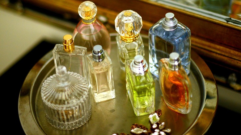 Decorative perfume bottles sit atop a round metal tray