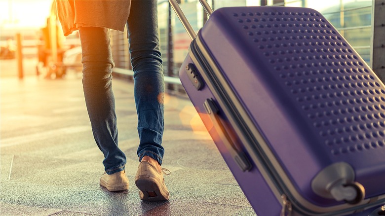 Traveler pulling suitcase through airport