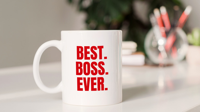 A desk setting with a prominent "Best. Boss. Ever." mug in the foreground.