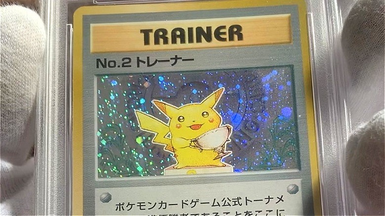 Gloved hand holds Pikachu card