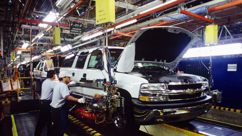 Auto workers building a behicle on an assembly line