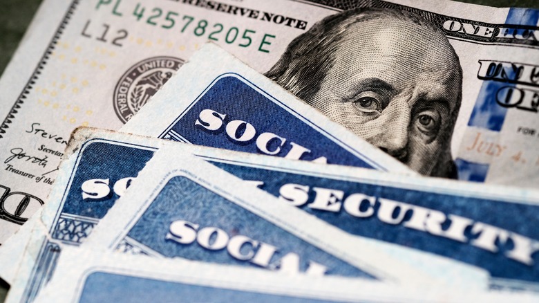 Social Security cards over a hundred dollar bill