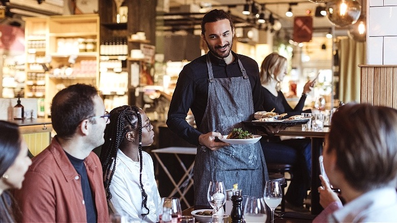 Waiter bringing food at restaurant