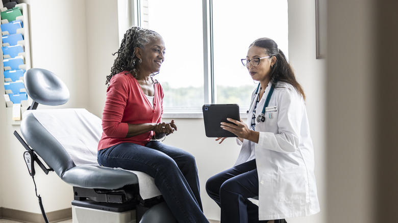 A smiling senior woman with her doctor in a doctor's office