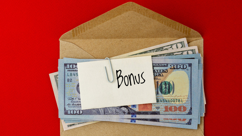 A few dollars on an envelope with the word "bonus" written on it