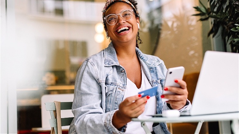 Person laughing with credit card