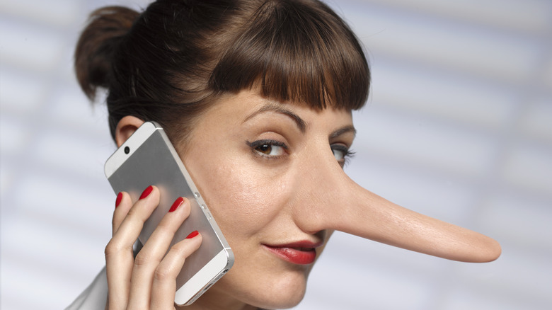 A woman with a long nose holding a phone to her ear.