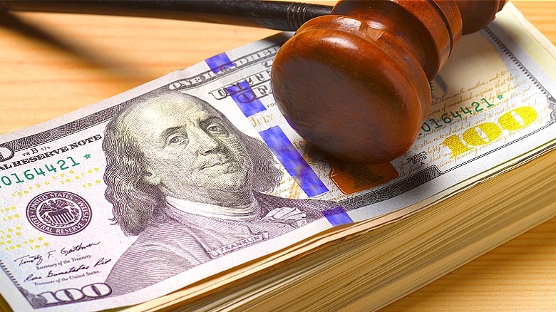 Gavel lying atop $100 stack