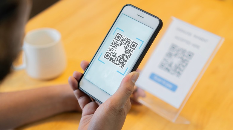 Person scanning QR code with their smartphone