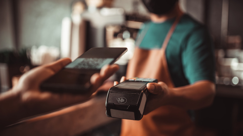 Person scanning QR code to pay at a business