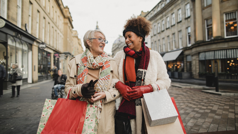 Two women walking down a street carrying shopping bags