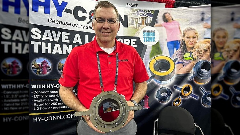 Jeff Stroope smiling while holding Hy-Conn at a trade show