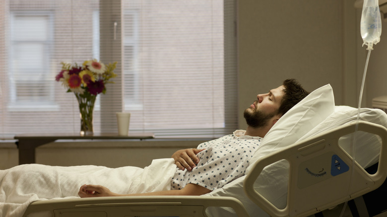 man lying in hospital bed