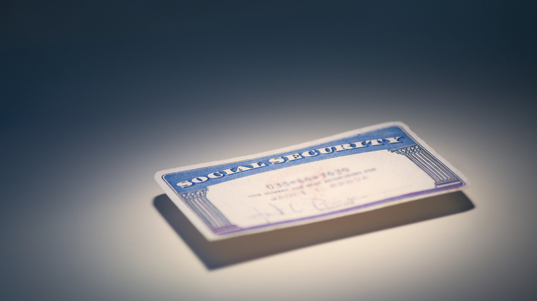 a social security card floating above lighted background