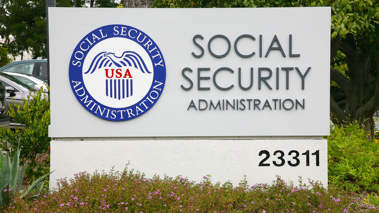 A concrete Social Security Administration office sign in shrubbery.