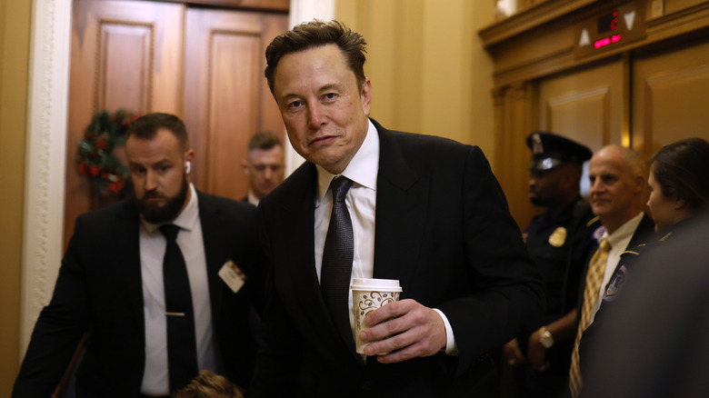 Elon Musk holds a takeaway coffee in Capitol Hill offices.