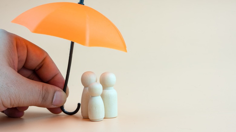 Umbrella over people figurines