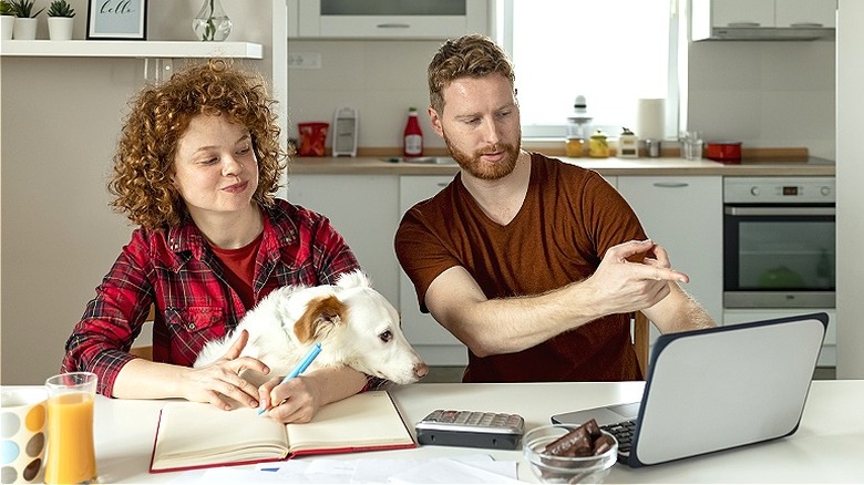 Couple and dog viewing laptop