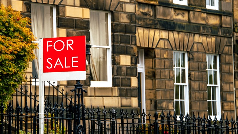 "FOR SALE" sign before residents