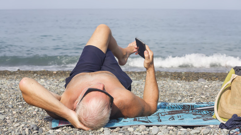 A retiree lying on a beach