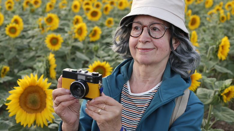 An elderly woman holding a camera